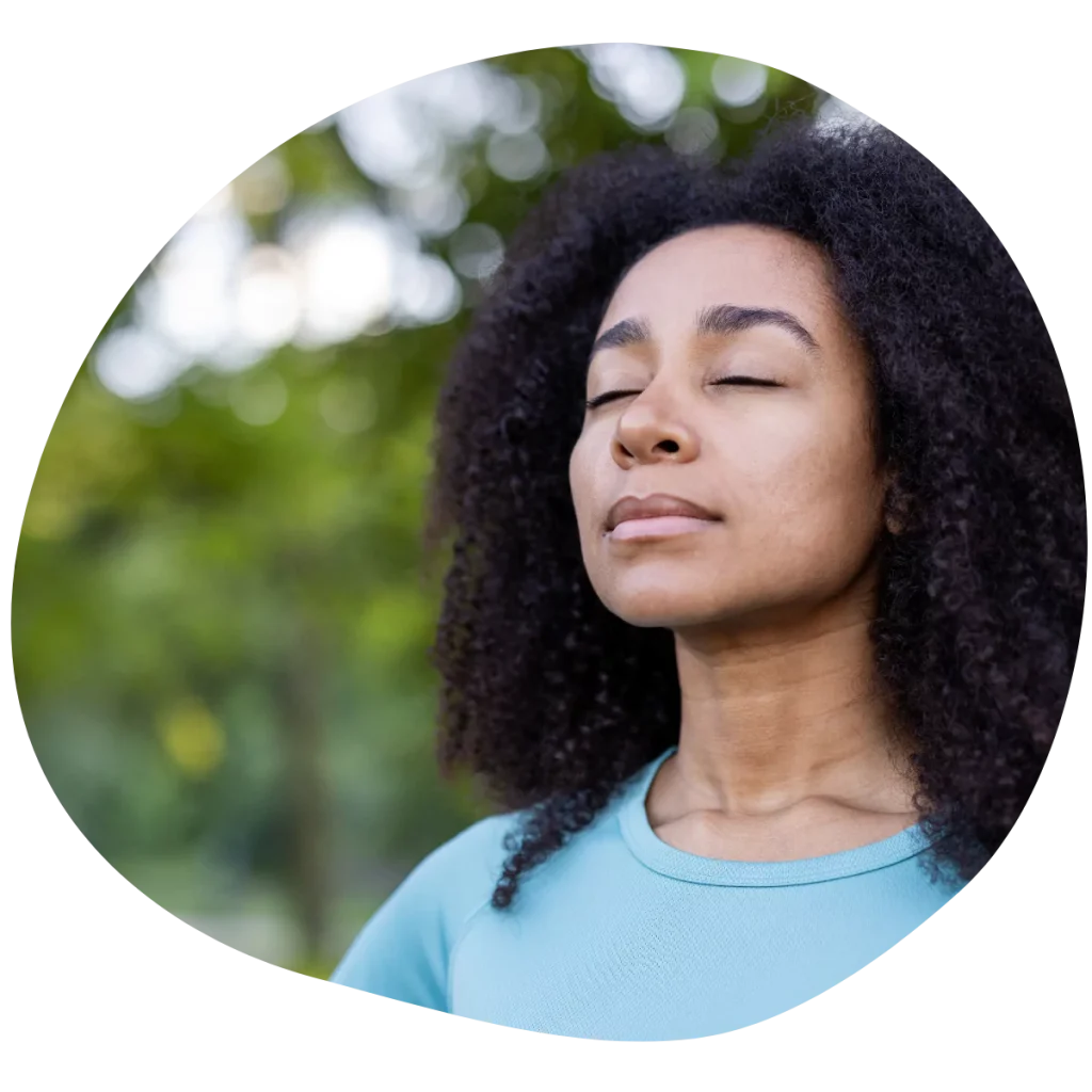 Woman practicing mindfulness outdoors with eyes shut